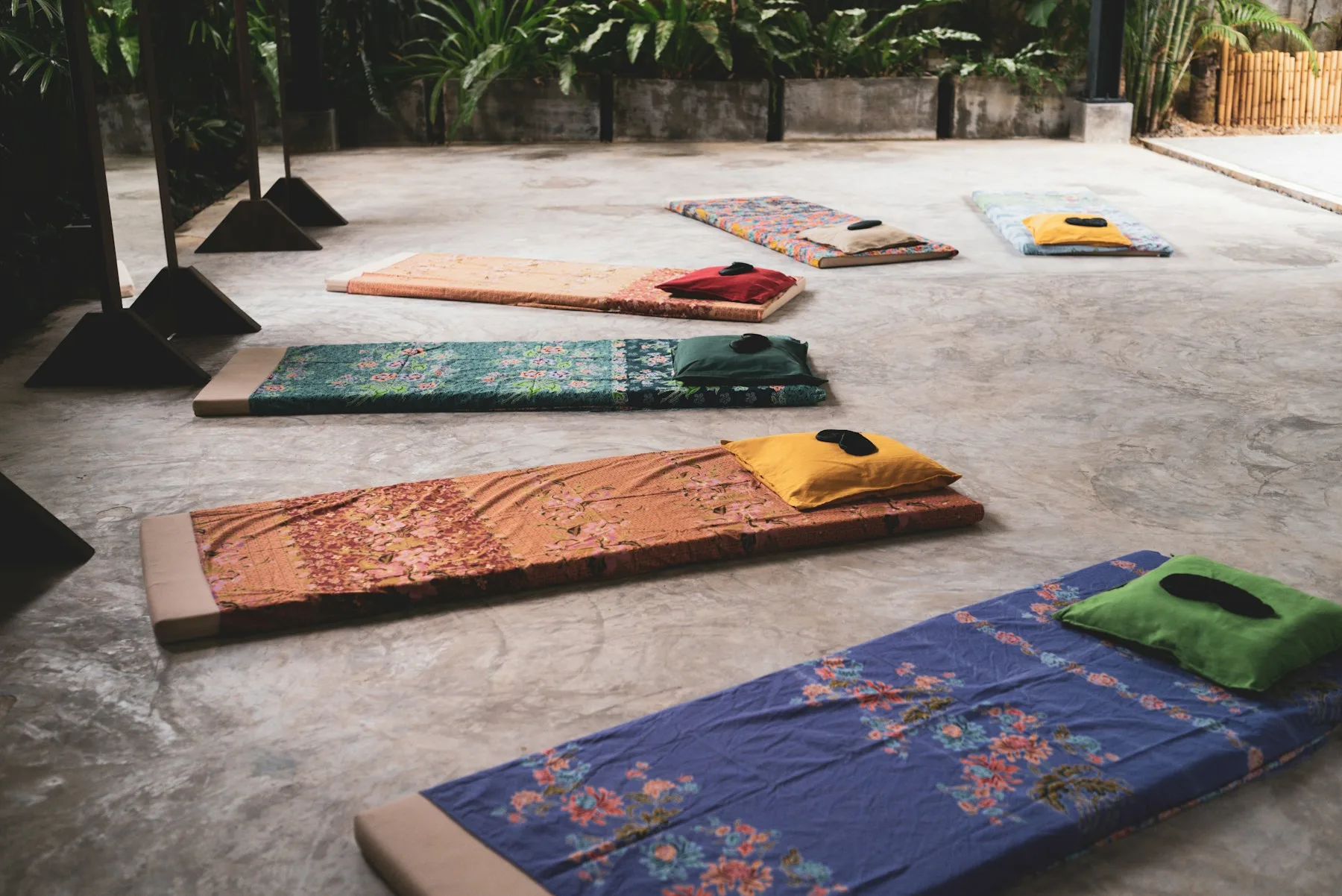Tapis, coussins et matériel prêts avant une séance collective de yoga.